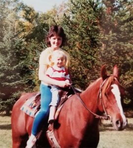 Linda Lovisa is riding her horse Geronimo; there are trees surrounding them.