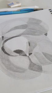 A doodle done with a pencil, with varying shades of grey, and done with more curving and circular lines, a piece from a Linda Lovisa class